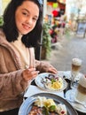 Young pretty brunette woman eating ice cream at the street cafe at Paris, France. Outdoor lifestyle portrait. Royalty Free Stock Photo