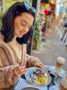 Young pretty brunette woman eating ice cream at the street cafe at Paris, France. Outdoor lifestyle portrait. Royalty Free Stock Photo
