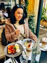 Young pretty brunette woman eating ice cream at the street cafe at Paris, France. Outdoor lifestyle portrait. Royalty Free Stock Photo