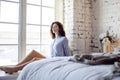 Young pretty brunette woman in her bedroom sitting at window, happy smiling lifestyle people concept Royalty Free Stock Photo