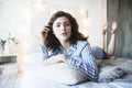 Young pretty brunette woman in her bedroom sitting at window, happy smiling lifestyle people concept Royalty Free Stock Photo