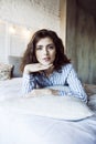 Young pretty brunette woman in her bedroom sitting at window, happy smiling lifestyle people concept Royalty Free Stock Photo