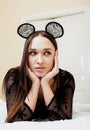 Young pretty brunette woman wearing lace mouse ears, laying waiting dreaming in bed Royalty Free Stock Photo