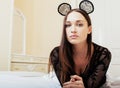 Young pretty brunette woman wearing lace mouse ears, laying waiting dreaming in bed Royalty Free Stock Photo