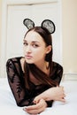 Young pretty brunette woman wearing lace mouse ears, laying waiting dreaming in bed Royalty Free Stock Photo
