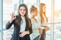Young pretty business girls show a good gesture. Dressed in classic clothes, Royalty Free Stock Photo