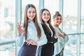 Young pretty business girls show a good gesture. Dressed in classic clothes, Royalty Free Stock Photo