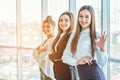 Young pretty business girls show a good gesture. Dressed in classic clothes, Royalty Free Stock Photo