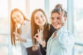 Young pretty business girls show a good gesture. Dressed in classic clothes, smiling copy space Royalty Free Stock Photo