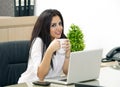 Young pretty business woman having coffee in office Royalty Free Stock Photo