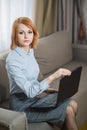 Young pretty business woman with laptop sitting on couch in the hotel room Royalty Free Stock Photo