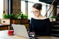 Young pretty business woman works on a laptop, uses a smartphone, a freelancer, a computer, financial analyst, a sales manager, pr Royalty Free Stock Photo