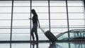 Young Pretty Businesswoman Using a Smartphone at Airport While Waiting Her Queue For Registration, Travelling Concept Royalty Free Stock Photo