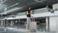 Young Pretty Businesswoman Using a Smartphone at Airport While Waiting Her Queue For Registration, Travelling Concept Royalty Free Stock Photo