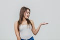 A young pretty Caucasian girl stood on a white background. During this time wear a white T-shirt and blue jeans. Turning Royalty Free Stock Photo