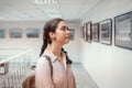 Young pretty caucasian thoughtful woman watching at the artwork. Side view. Exhibition in the art gallery. Excursion and Royalty Free Stock Photo