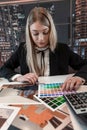 Young pretty caucasian woman interior designer with house plan and choose color catalog Royalty Free Stock Photo