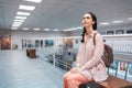 Young pretty caucasian woman sitting on bench contemplating at the artwork. Exhibition in the art gallery. Excursion and Royalty Free Stock Photo