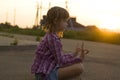 Young pretty child girl with funny braids training yoga exercise alone outdoors on misty rural background at dawn or sunset Royalty Free Stock Photo