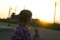 Young pretty child girl with funny braids training yoga exercise alone outdoors on misty rural background at dawn or sunset Royalty Free Stock Photo