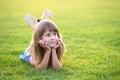 Young pretty child girl laying down on green grass lawn on warm summer day Royalty Free Stock Photo