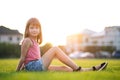 Young pretty child girl laying down on green grass lawn on warm summer day Royalty Free Stock Photo