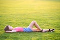 Young pretty child girl relaxing lying down on green grass on warm summer evening Royalty Free Stock Photo