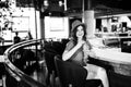 Young pretty cute brunette sitting in a restaurant behind a bar and drinking a cocktail. Summer style Royalty Free Stock Photo