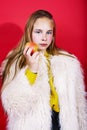 Young pretty emitonal posing teenage girl on bright red background eating apple, happy smiling lifestyle people concept Royalty Free Stock Photo