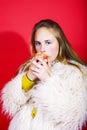 Young pretty emitonal posing teenage girl on bright red background eating apple, happy smiling lifestyle people concept Royalty Free Stock Photo