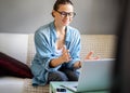 Young pretty european woman with glasses psychologist coach holds an online session on the internet, remote work from home, online Royalty Free Stock Photo