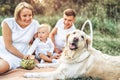 Young cute family on picnic with dog Royalty Free Stock Photo