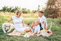 Young cute family on picnic with dog Royalty Free Stock Photo