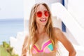 Young pretty fashion woman in red sunglasses posing outdoor in summer on tropic island in hot weather in bikini fashion photo of