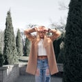 Young pretty fashionable blonde woman dressed in ripped jeans and white sweater