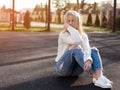 Young pretty fashionable blonde woman dressed in ripped jeans Royalty Free Stock Photo