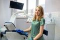 Young pretty female dentist stomatology in uniform and gloves at workplace cabinet Royalty Free Stock Photo