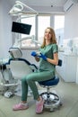 Young pretty female dentist stomatology in uniform and gloves at workplace cabinet Royalty Free Stock Photo