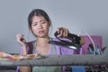 Young pretty frustrated and stressed Asian Chinese woman with iron working at home kitchen ironing clothes desperate and overwhelm