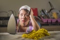 Young pretty frustrated and stressed Asian Chinese woman with iron working at home kitchen ironing clothes desperate and overwhelm Royalty Free Stock Photo