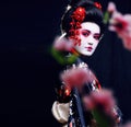 Young pretty geisha in kimono with sakura and decoration on black background Royalty Free Stock Photo