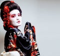 young pretty geisha in kimono with sakura and red decoration des Royalty Free Stock Photo