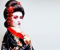young pretty geisha in kimono with sakura and red decoration des Royalty Free Stock Photo