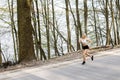 A young, pretty girl blonde runs outdoors in the woods near the lake with beautiful scenery. Sports activity. Exercise Outdoors.