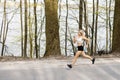 A young, pretty girl blonde runs outdoors in the woods near the lake with beautiful scenery. Sports activity. Exercise