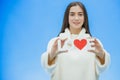 Young pretty girl dressed in white clothes. During this time it stands on a blue background. Holds a word of love in