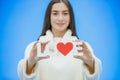 Young pretty girl dressed in white clothes. During this time it stands on a blue background. Holds a word of love in