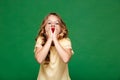 Young pretty girl eating raspberry over green background. Royalty Free Stock Photo