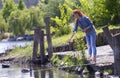 Young pretty girl feeding wild duck while fishing, lake weekend. Kyiv, Ukraine