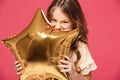 Young pretty girl holding baloon and smiling over pink background. Royalty Free Stock Photo